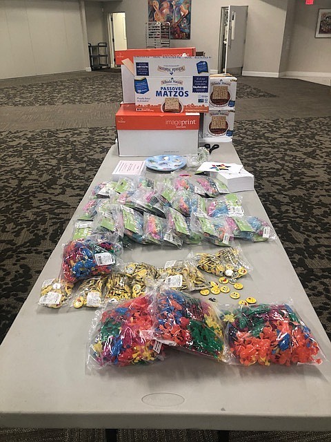 Temple Emanu-El Seder Kit items are organized for assembly and packing.