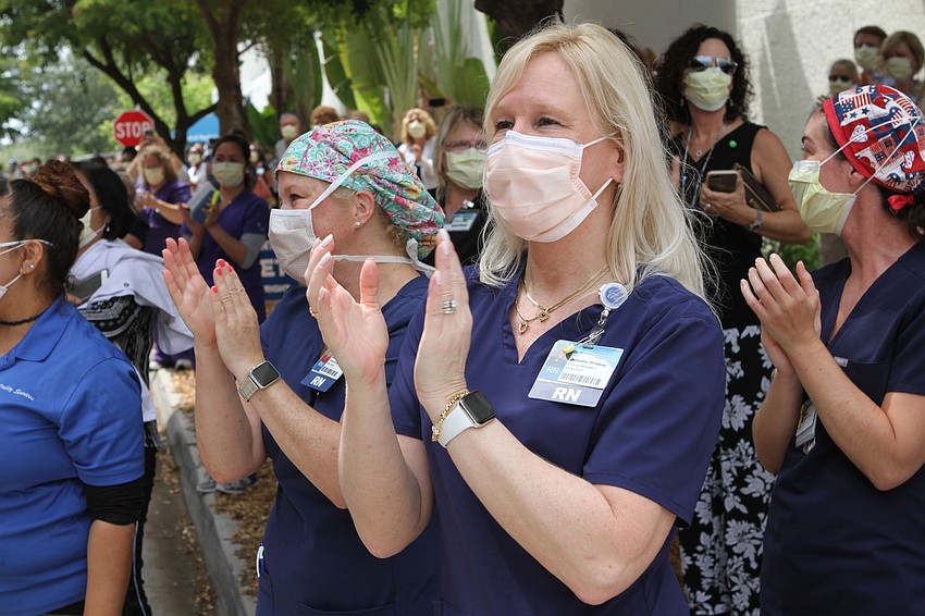 Jennifer Prinkey claps for the emergency personnel as they salute the nurses. Harry Sayer