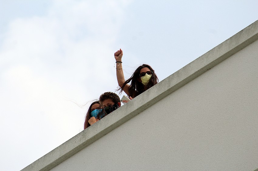 Some hospital personnel gather on the roof of a parking garage to watch the ceremony while avoiding the crowd. Brynn Mechem