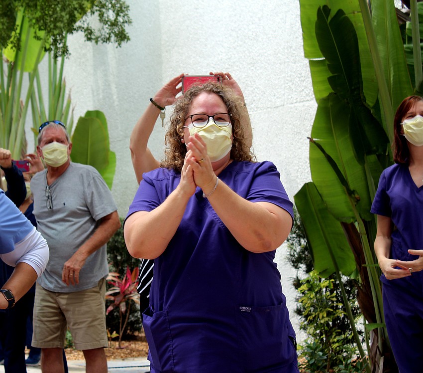 Julie Ennis claps as the emergency personnel salutes the doctors. Brynn Mechem