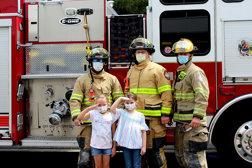 Marilyn Habib and Francesca DiSilvio take a photo with Sarasota County firefighters. Brynn Mechem
