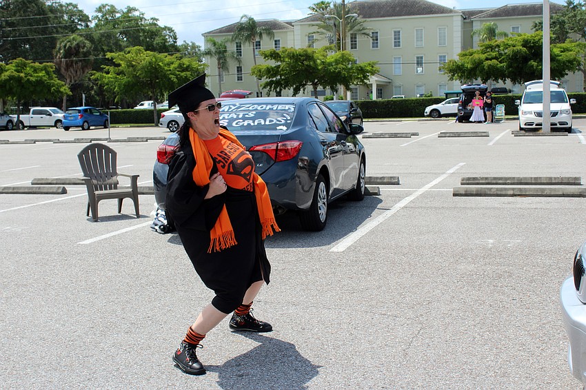 Sarah Sturzu tries to make students laugh as they drive by.