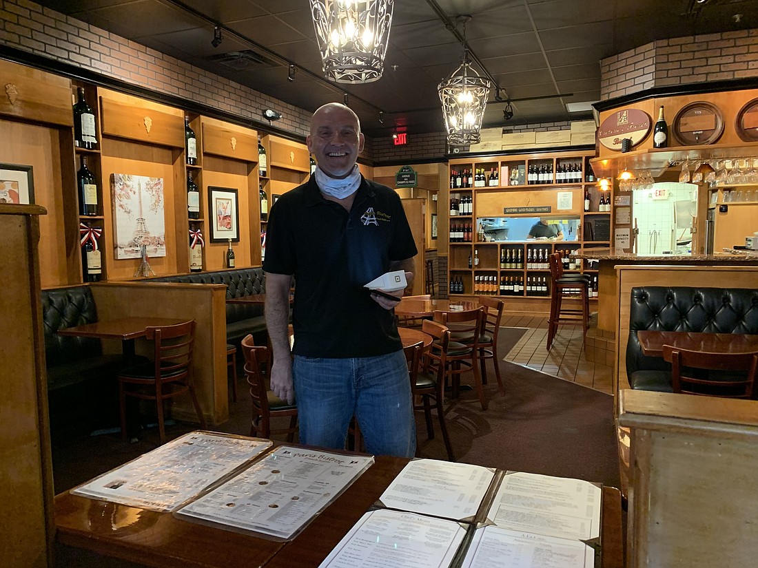 Pierre Bosse, a waiter at Paris Bistrot, helps prepare takeout and curbside orders for customers. In the 12 years the restaurant has been open, it has not done curbside pickup and had few takeout orders.