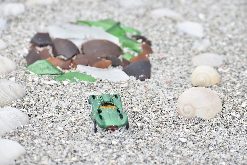 A toy car guards a collection of sea glass.