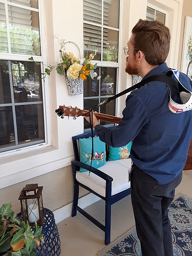 Tidewell Hospice Music Therapist Michael Russo plays outside a patientâ€™s window at Brookdale of Punta Gorda. Courtesy photo.