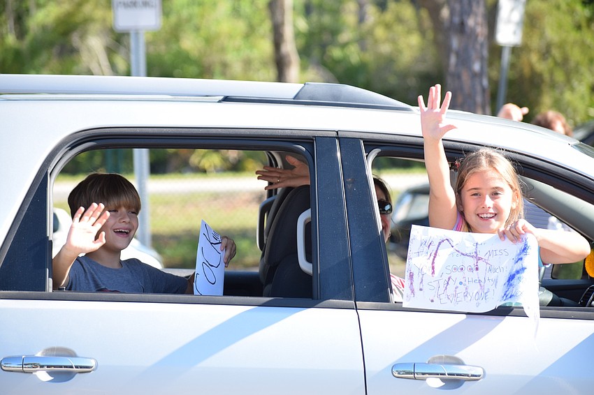 Tara Elementary School second grader Grayson Marinetti and his sister Quinn, who is in fourth grade, wave to teachers as they participate in the parade for first and second grade teachers.