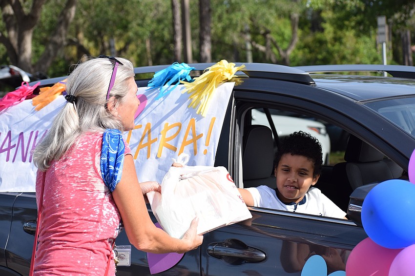 Jennifer Scheid, a fifth grade teacher at Tara Elementary School, collects books from Wesley Murrell.