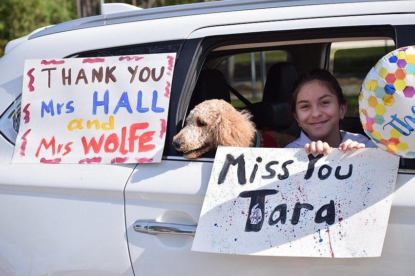 Anna Antony, a fifth grader at Tara Elementary School, holds signs she made to show appreciation for her teachers.