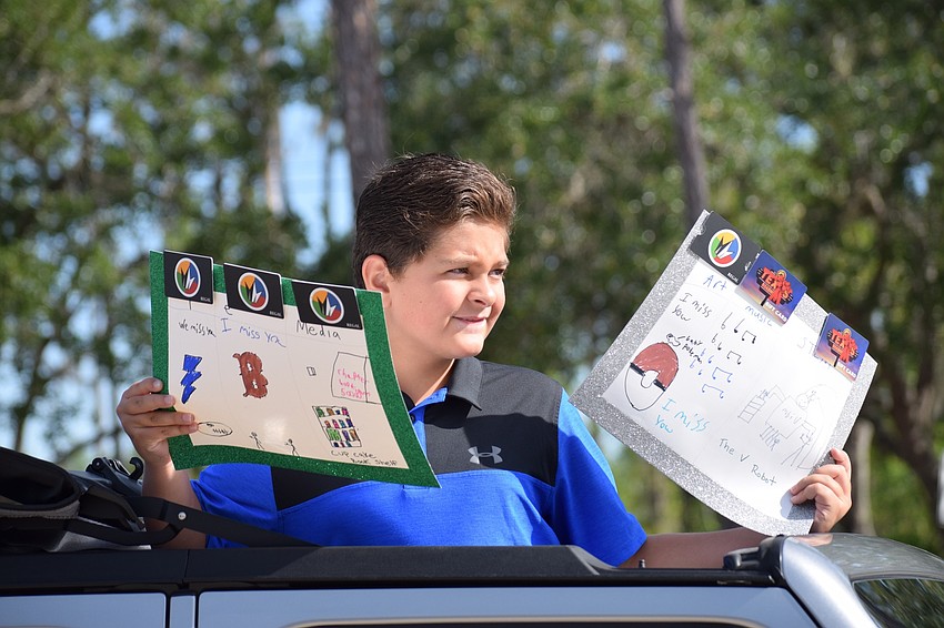 Cooper Smith, a fifth grader at Tara Elementary School, stands out of his car's sun roof holding signs he made for his teachers during the parade.