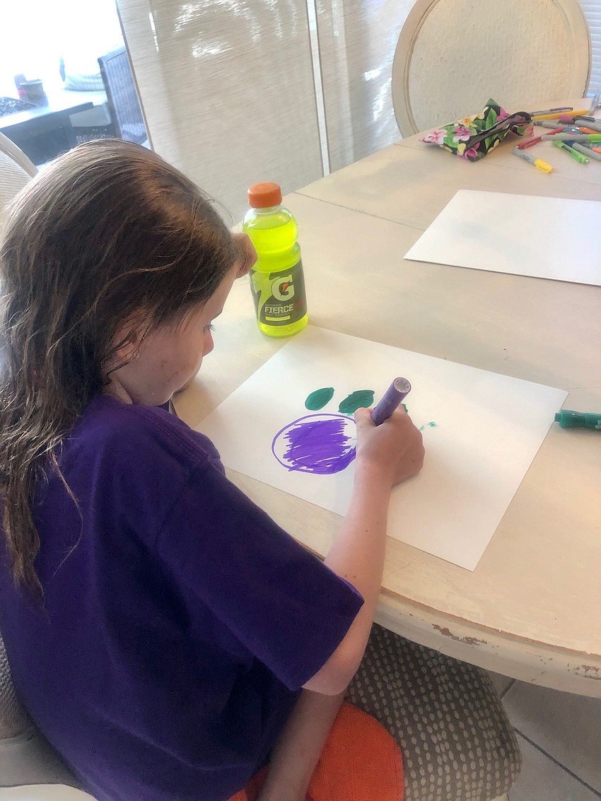 Daphne Quintal, a first grader at Gilbert W. McNeal Elementary School, makes a homemade sign for teachers and staff members at the school to show her appreciation for all they do.