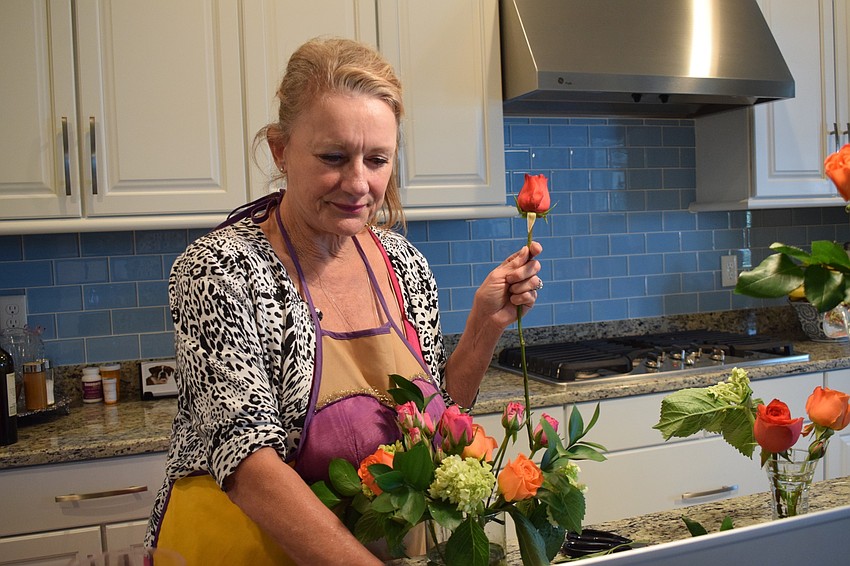 Jacquie McLaurin, a fifth grade teacher at Robert E. Willis Elementary, puts a rose in her arrangement. McLaurin swapped two of her orange roses with fifth grade teacher Suzanne Tomlin's pink roses.