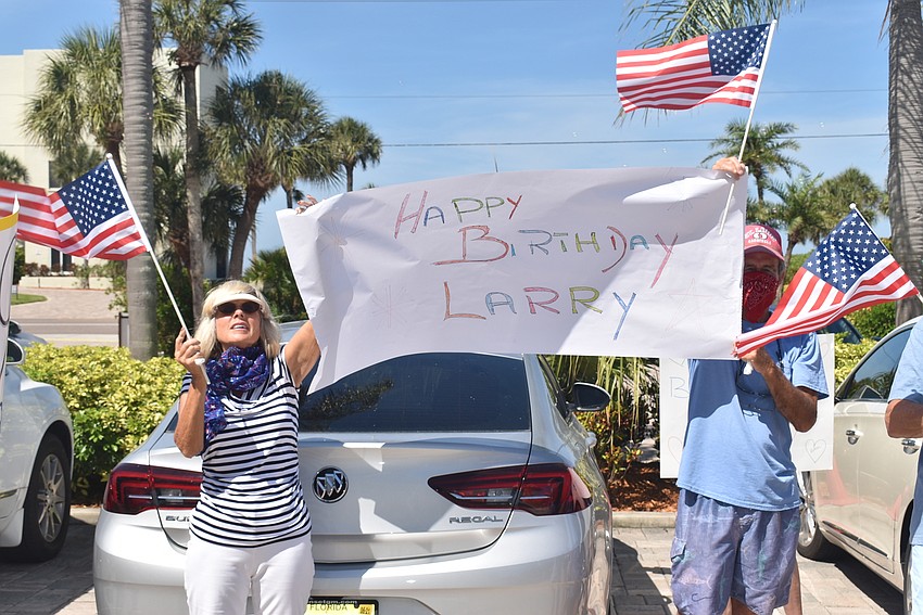 Mary Ann and Kirt Bopp hold up a sign.