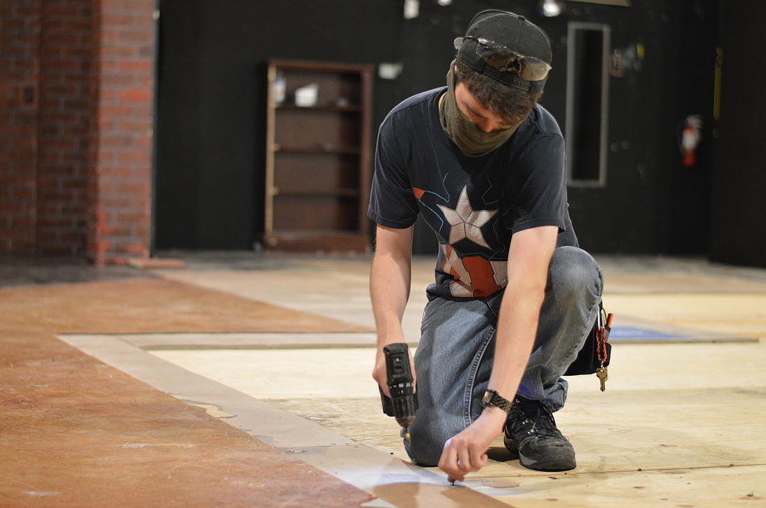 Scenic Production intern Justin Allan works on the floor of the Gompertz Theatre. Photo courtesy Sarah Haley.