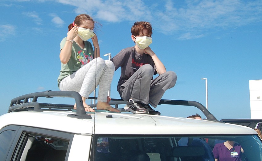 Kendall and Brian Casey watch for the approach of an Air Force KC-135 from the roof of their father's car.