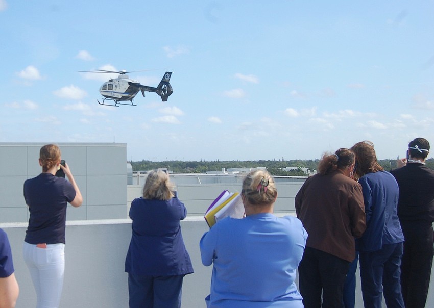 Staff on hand for the Air Force flyover watch as Sarasota Memorial Hospital's trauma helicopter lands.