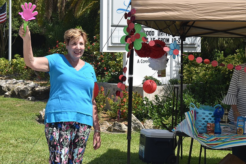 Karen Pashkow rattles a noisemaker to attract attention from drivers.