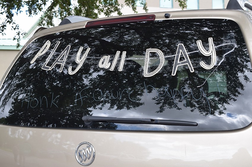 Missy Parmenter, an associate pastor for Oasis Church, decorates the back of her car to encourage people to honk their car horns if they're happy.