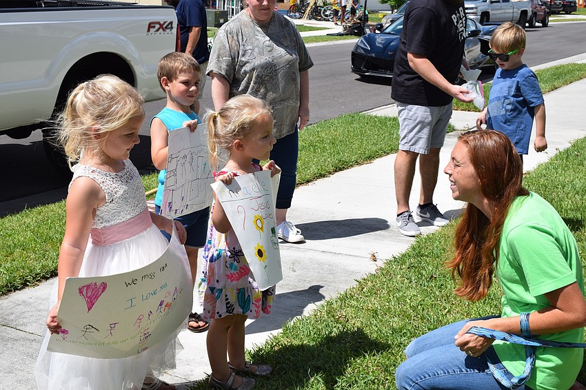 Lilah and Annabelle Peele and Elijah Johnson show their signs to Bethany Laney.