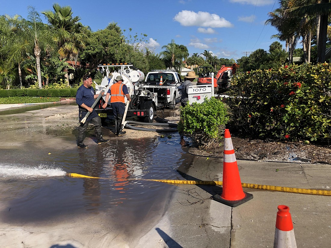 Workers pump water from the site of a 10-inch pipe break on Bogey Lane.