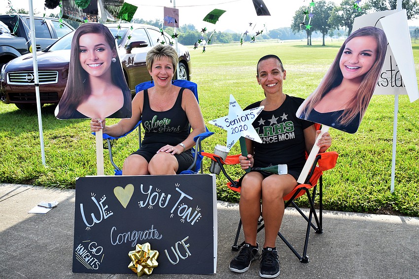 Diana Martin holds up a cutout of her daughter Brooke and Angela Gulbrandsen, holds up a cutout of her daughter Toni. Brooke Martin and Toni Gulbrandsen are seniors this year and were on the Silver Stars dance team together.