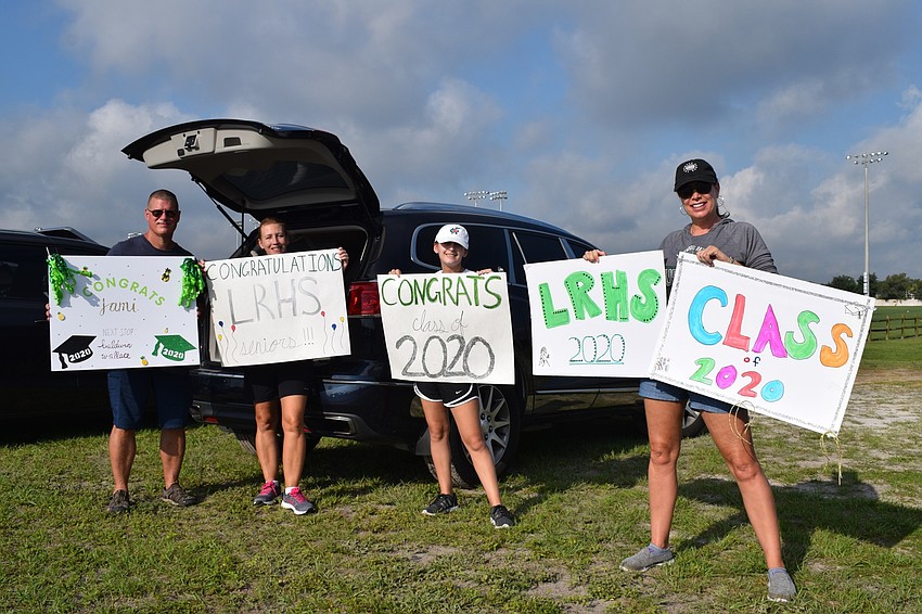 Todd Melzer, Greta and Emily Miller and Marni Mount show off the signs they made for seniors. 
