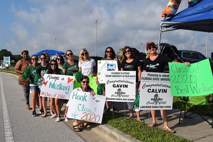 Dozens of Lakewood Ranch High School parents line Mustang Alley for a surprise parade for seniors who are picking up their caps and gowns.