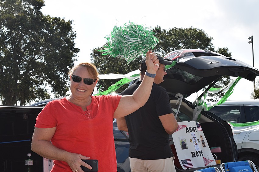 Angie and Larry Jackson use pom poms and signs to cheer for seniors. 