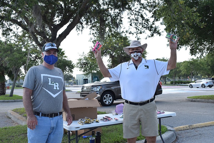 Science teachers Larry Hickman and Faust Delazzer wish they could hug their seniors or shake their hands as they see them drive through to get their caps and gowns.
