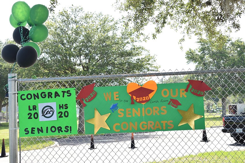 Teachers and staff post signs congratulating seniors.
