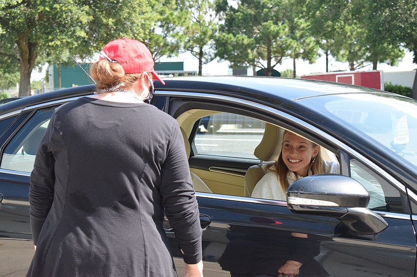 Macie Adams, a math teacher, talks to senior Samantha van der Sommen as she waits for her cap and gown.
