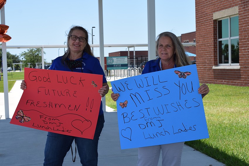 Ginger Thomas and Eileen Parker, cafeteria staff members at Mona Jain Middle, make signs to congratulate eighth graders. 