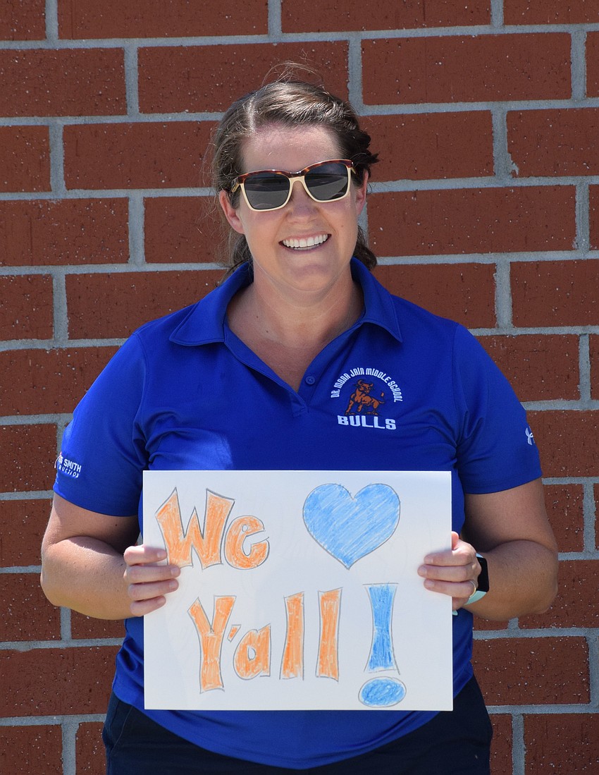 Alexis Rivard, an eighth grade science teacher, shares that she loves her students in a sign she made.