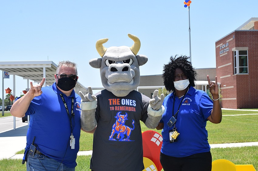 Steven Zickafoose, Mona Jain's assistant principal, and Angela Lindsey, the school's principal, ask students if they want to take a photo with the school's mascot.