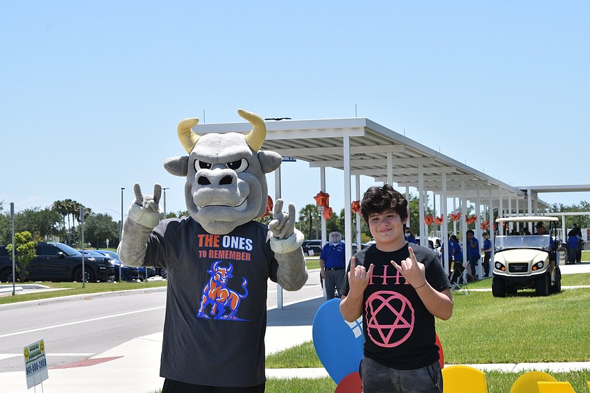 Mona Jain eighth grader Luis Aguero takes a photo with the school's mascot to celebrate the end of the year and his graduation from the school.