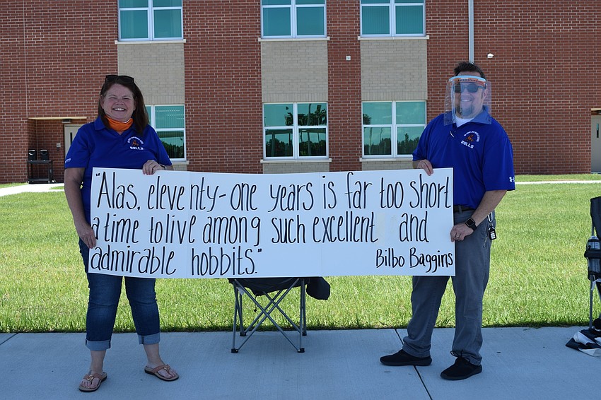 Kim Brown and Adam Nowicki show off the sign they made for the parade. Brown and Nowicki worked with the school's Technology Student Association to make masks and face shields for health care workers while doing e-learning.
