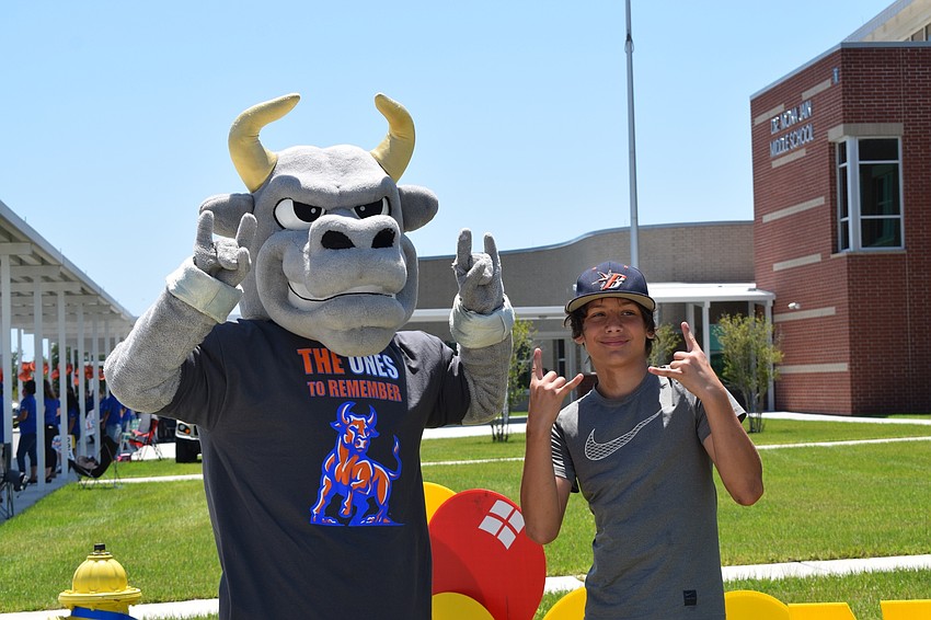 Mona Jain's mascot and eighth grader Aiden Csogi give the Mona Jain bull sign.