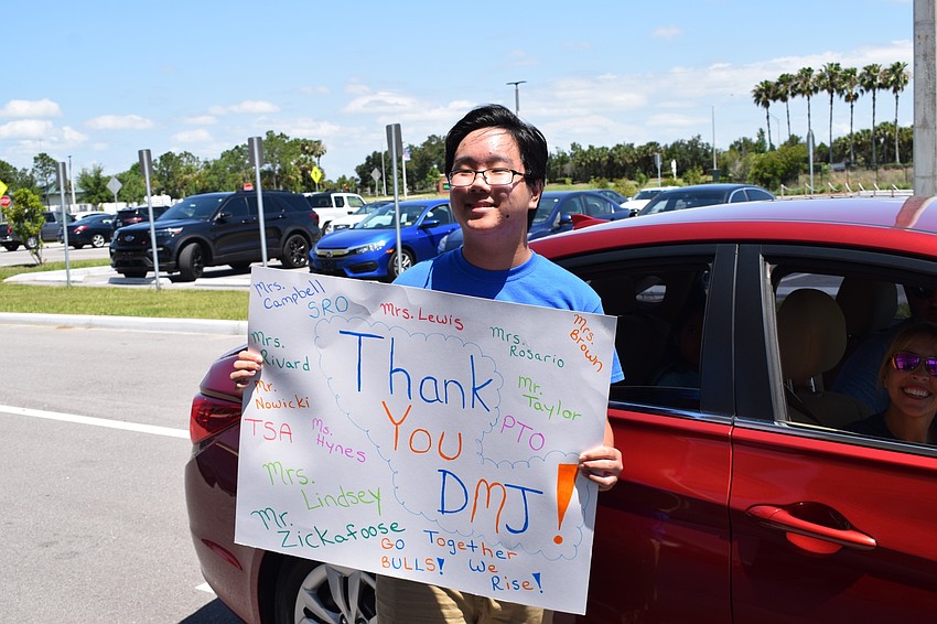 Mona Jain eighth grader Spencer Boyer shows school teachers and staff members the sign he made to show his appreciation.