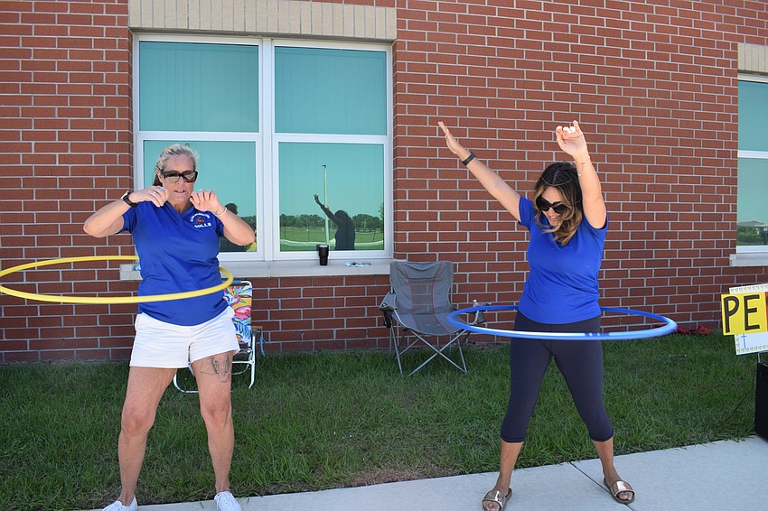 Wende Wicks and Jillian Cucci, intensive reading teachers at Mona Jain Middle, hula hoop during the parade.