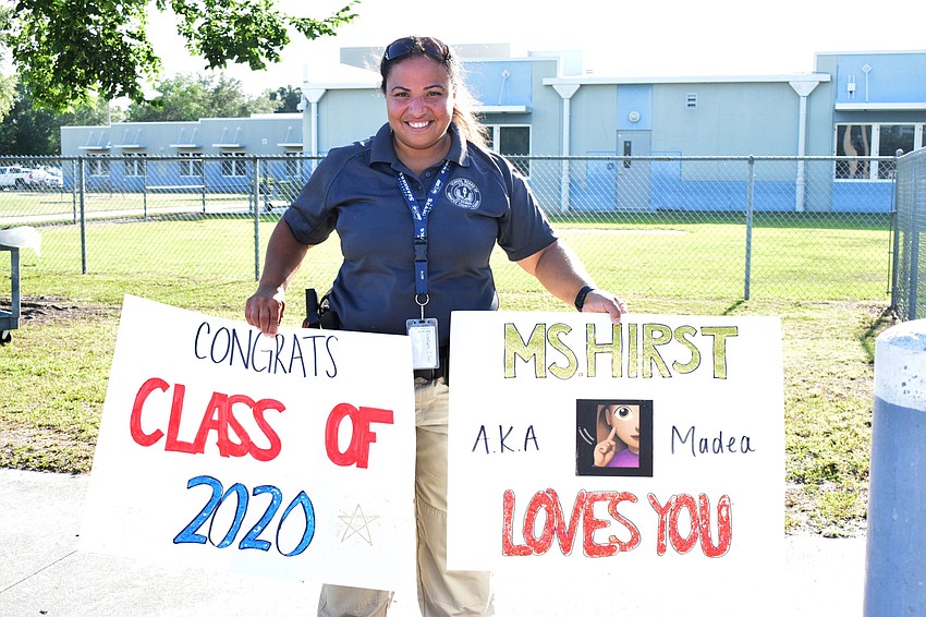 Elizabeth Liles, a Guardian based out of Freedom Elementary, helps hold up signs during the fifth grade parade.