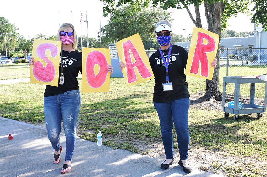 Kenzie Cleveland and Sherri Brunner, school counselors at Freedom Elementary, hold up signs the fifth graders have seen since they were in kindergarten.