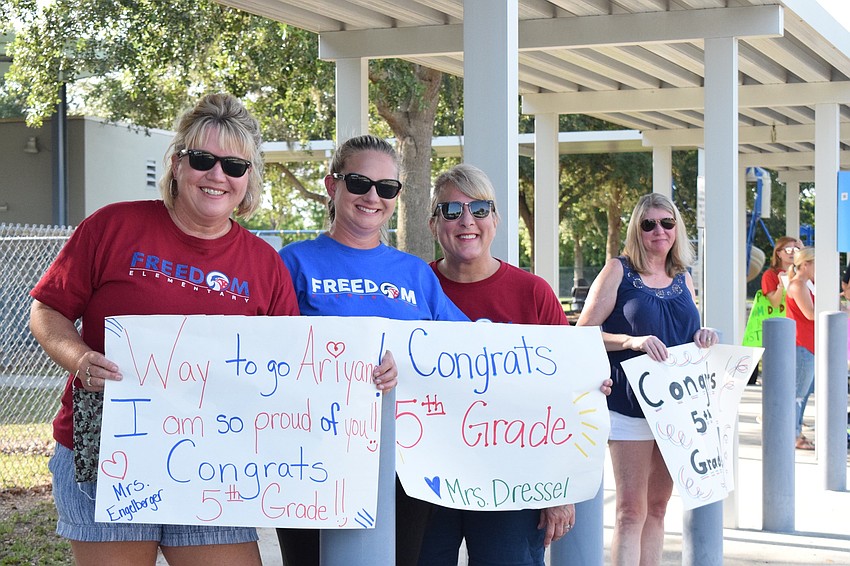 First grade teachers Kristie Engelberger, Sami Dressel, Ruth Ann Watts and STEM teacher Debbie Smith cheer for fifth graders as they drive by in a parade.