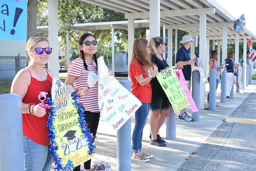 Jena Harnish, Chelsea Rademaker, Katie Kandel and Cindy Brumbaug cheer for fifth graders as they pass by.