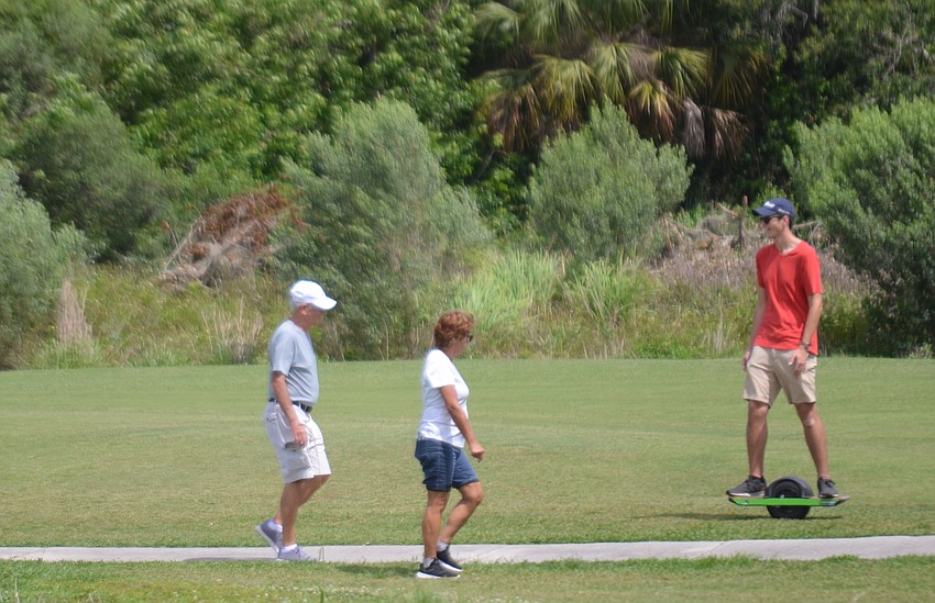 Walkers encounter a motorized unicycle skateboarder.