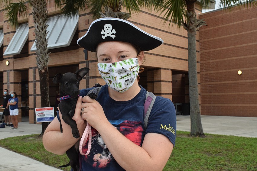 English and drama teacher Barbara Helfrick brings her puppy Ellie to congratulate the seniors coming to pick up their caps and gowns.