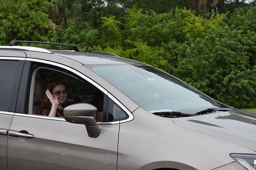 Senior Madigan Wilford waves to her teachers as she gets her cap and gown.
