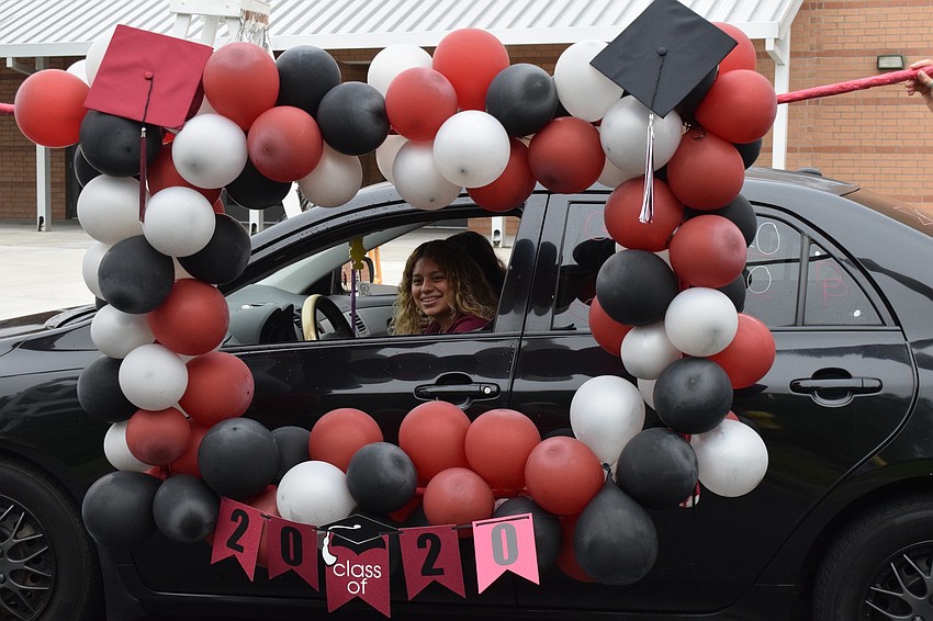 Senior Denise Perez stops her car so Braden River High School teachers can frame her and digital photography teacher John Frank can take her photo.