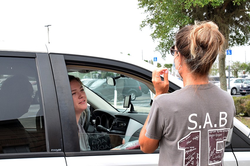 Senior Faith Gamborota chats with business teacher Stefanie Minihan. The two have stayed connected while students haven't been allowed on campus due to COVID-19.