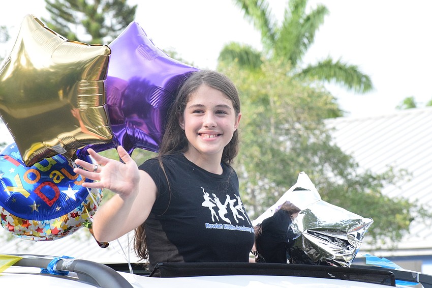 Autymn Prater, an eighth grader, waves to teachers and staff members in her decorated car to celebrate her graduation from Rowlett Middle Academy.