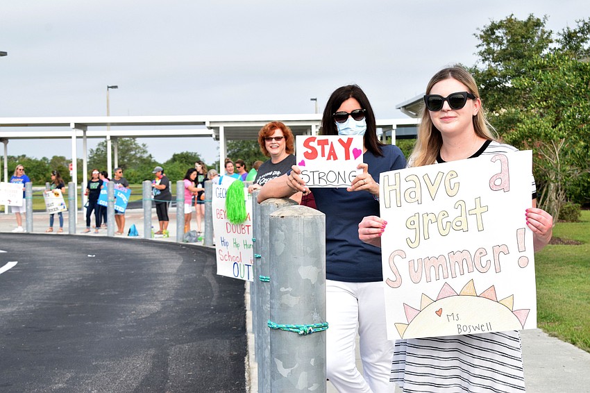 Robert E. Willis Elementary teachers Julie Santello, Laurie Rahn and Courtney Boswell hold up the signs they made for the end-of-the-year parade.