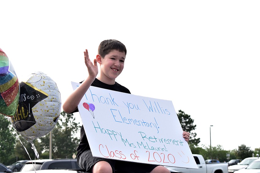 Aiden Torres, a fifth grader at Robert E. Willis Elementary, waves to teachers and staff members while also congratulating fifth grade teacher Jacquie McLaurin on her retirement.